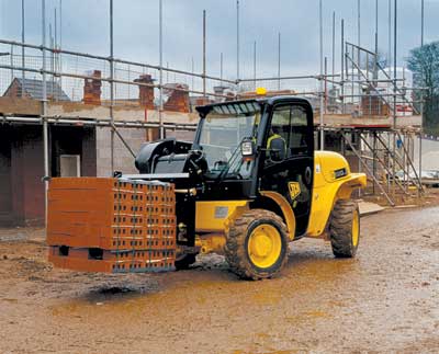 A telehandler lifting a pallet of construction material