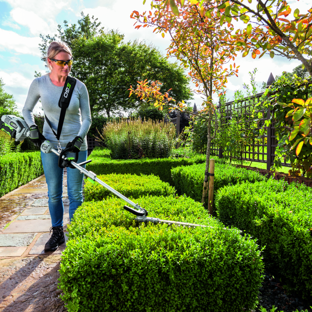 Woman using an ego hedge trimmer