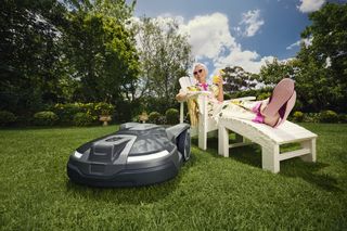 A woman relaxing in the garden while her Automower cuts the lawn