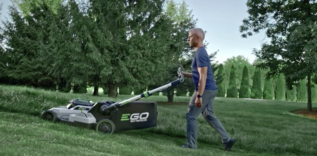 Man pushing an EGO Battery Mower up a hill