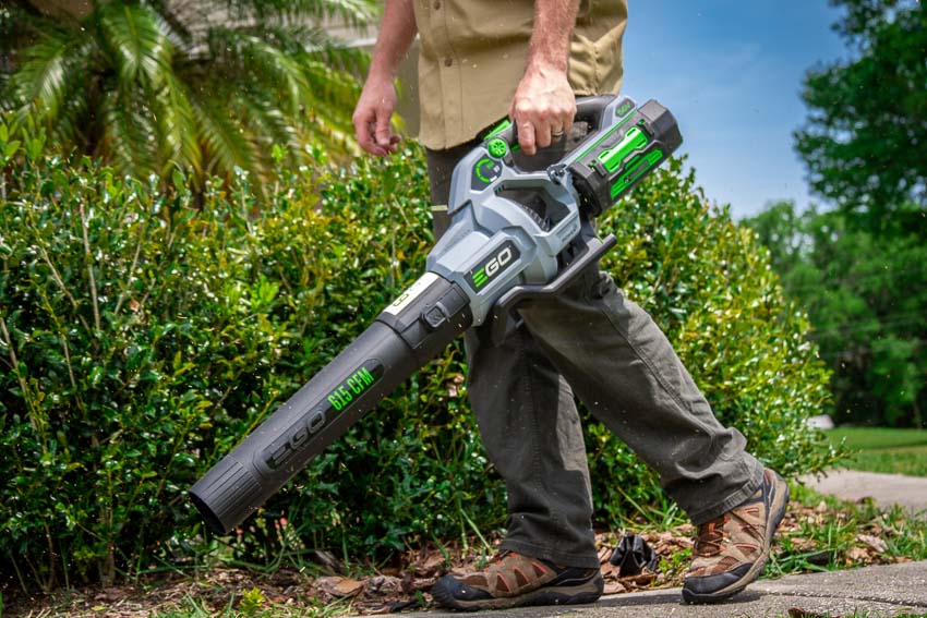 Person carrying a handheld leaf blower